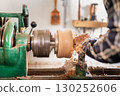 Carpentry. Turnery of a wooden bowl with spiral sawdust shavings with hand and chisel 130252606