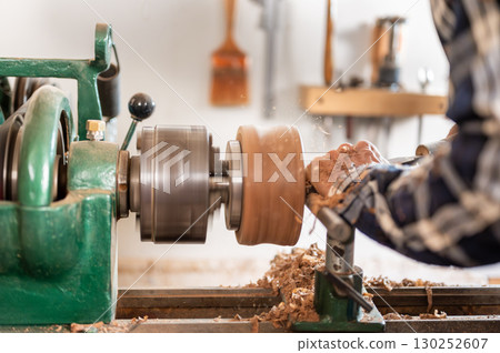 Carpentry. Turnery of a wooden bowl with spiral sawdust shavings with hand and chisel 130252607