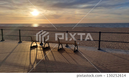 Wood empty bench on the beach embankment. Sanset near the sea. Ostende, Belgien. Wood empty bench on the beach embankment. Sanset near the sea. Ostende, Belgien. 130252614