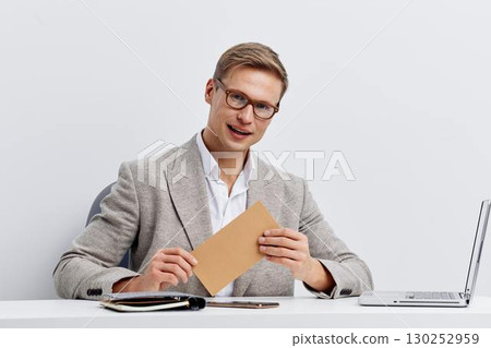 young man working digital nomad casual wear eyeglasses laptop writing notepad smiling light background freelance concept young man working digital nomad casual wear eyeglasses laptop writing notepad smiling light background freelance concept 130252959