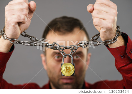 Man being tied up in block chain 130253434