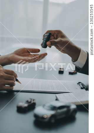 Car salesman gave the keys to the customers who signed the purchase contract legally, Successful completion of car sales, Purchase contract and key delivery. 130253545