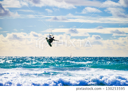Kite surfer riding waves. Kiteboarding sport. 130253595
