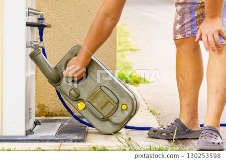 Man emptying caravan tank toilet cassette in dump station. Man emptying caravan tank toilet cassette in dump station. 130253598