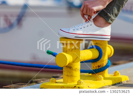Woman tying laces in sneakers outdoors 130253625