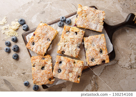 Blueberry cake with a nutty almond taste and juicy blueberries in every bite closeup on the wooden board. Horizontal top view 130254108