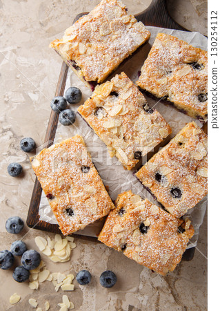 Blueberry Almond Pie is extra moist, tender, full of blueberries, and has the goodness of almonds closeup on the wooden board on the table. Vertical top view 130254112