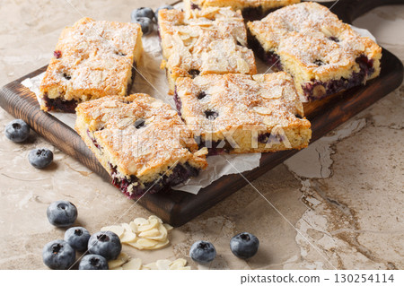 Blueberry cake with a nutty almond taste and juicy blueberries in every bite closeup on the wooden board. Horizontal 130254114