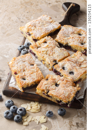 Soft and moist blueberry almond cake closeup on the wooden board. Vertical 130254115