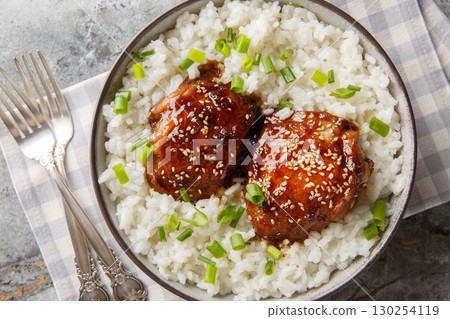 Shoyu Chicken is a classic Hawaiian dish featuring tender, juicy chicken simmered in a savory-sweet shoyu soy sauce served with white rice closeup. Horizontal top view Shoyu Chicken is a classic Hawaiian dish featuring tender, juicy chicken simmered in a savory-sweet shoyu soy sauce served with white rice closeup. Horizontal top view 130254119