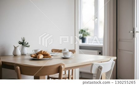 Cozy Breakfast Scene with Croissants and Coffee on Wooden Table Near Bright Window 130255265