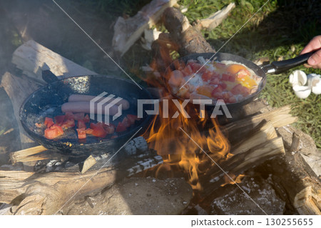 scrambled egg fried on coals in a pan on fire 130255655