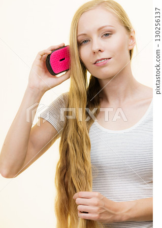 Blonde girl brushing her long hair Blonde girl brushing her long hair 130256137