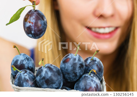 Girl holds plum fruits 130256145