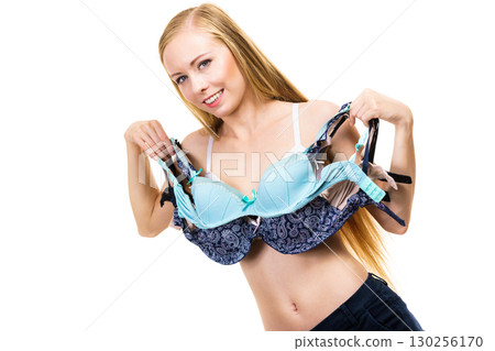 Woman holds bras, choosing 130256170