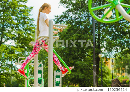 Woman doing exercise in outdoor gym 130256214