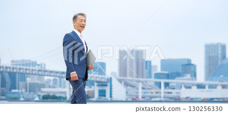 步行穿過建築物的商人 130256330