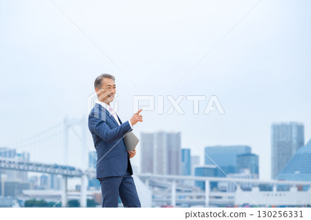 步行穿過建築物的商人 130256331