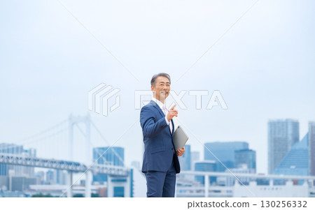 步行穿過建築物的商人 130256332