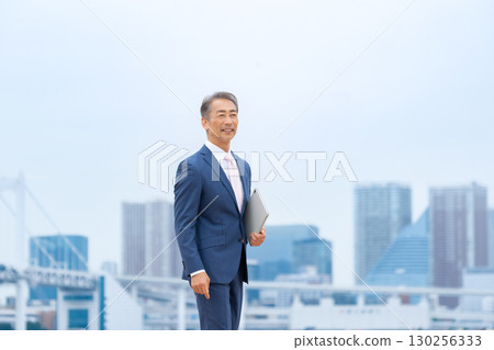 Businessman walking through buildings 130256333