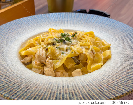 Delicious pasta with creamy sauce and chicken. Restaurant cuisine, gourmet dining, and authentic Italian food photography. Delicious pasta with creamy sauce and chicken. Restaurant cuisine, gourmet dining, and authentic Italian food photography. 130256582