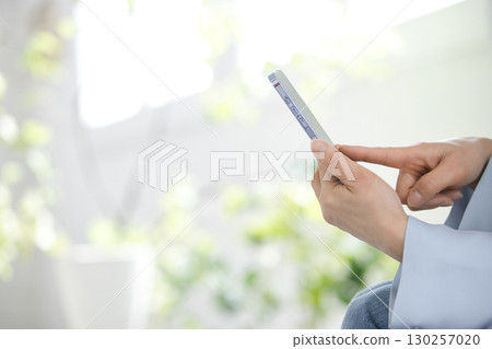 Hands of a middle-aged woman who operates a smartphone 130257020
