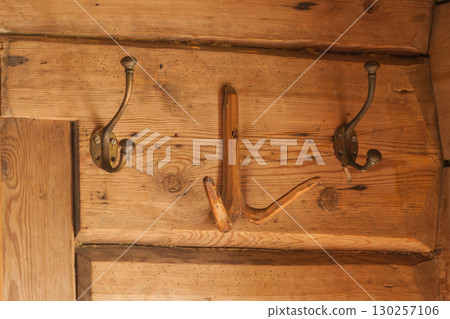 Vintage copper hangers on wooden wall Vintage copper hangers on wooden wall 130257106