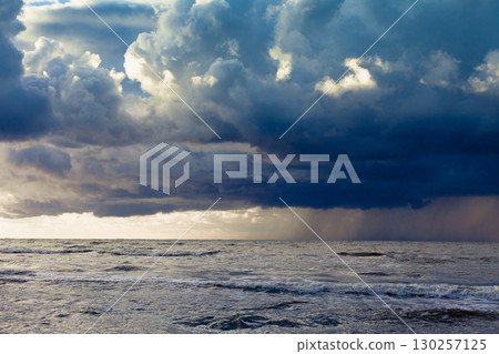 Beginning of the storm rain in ocean, dark cloudy sky 130257125