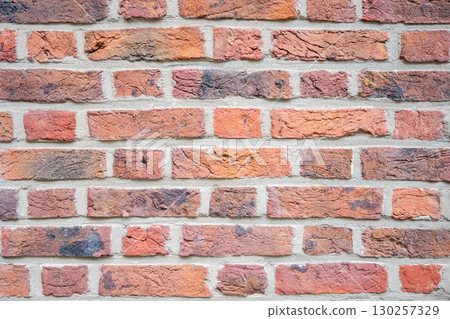 Brown structural stone wall of the ancient building consists of bricks. Nature structural background. 130257329