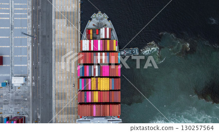 Aerial view container cargo ship at port with tugboat, Business global import export logistic maritime transport by container cargo ship vessel, International trade container cargo freight shipping. 130257564