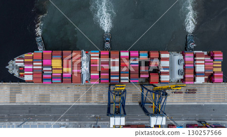 Aerial view container cargo ship at port with tugboat, Business global import export logistic maritime transport by container cargo ship vessel, International trade container cargo freight shipping. 130257566