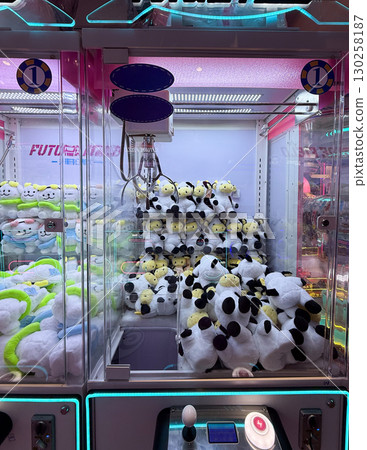 Plush toys inside claw machines in arcade hall. Leisure, entertainment, and playful atmosphere for childhood memories. Plush toys inside claw machines in arcade hall. Leisure, entertainment, and playful atmosphere for childhood memories. 130258187