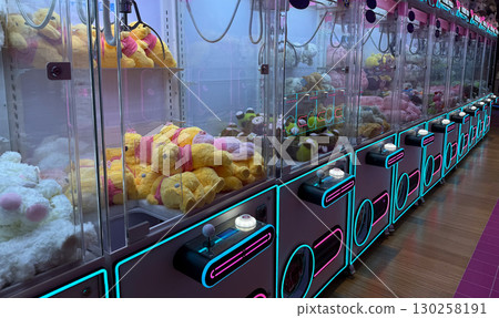 Claw machines filled with colorful plush toys. Entertainment, childhood nostalgia, and leisure in modern arcade game halls. Claw machines filled with colorful plush toys. Entertainment, childhood nostalgia, and leisure in modern arcade game halls. 130258191