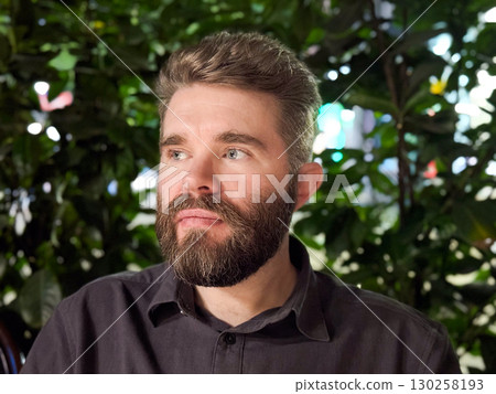 Man at night cafe. Social connection, relaxation, and joyful communication during evening leisure outdoors. Man at night cafe. Social connection, relaxation, and joyful communication during evening leisure outdoors. 130258193