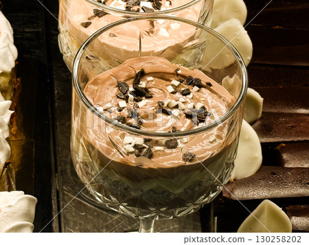 Chocolate mousse dessert in elegant glass. Sweet gourmet treat with cream and decorative toppings. Chocolate mousse dessert in elegant glass. Sweet gourmet treat with cream and decorative toppings. 130258202