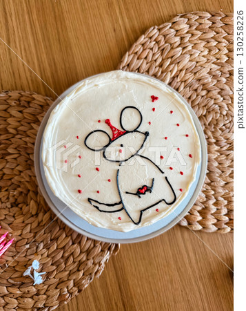Birthday cake with cute mouse drawing and festive decoration. Creative homemade dessert with white icing and minimalist design. 130258226