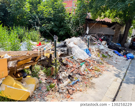 Pile of garbage and plastic waste among green grass. Pollution, environmental damage, and ecological issues in urban surroundings. Pile of garbage and plastic waste among green grass. Pollution, environmental damage, and ecological issues in urban surroundings. 130258229