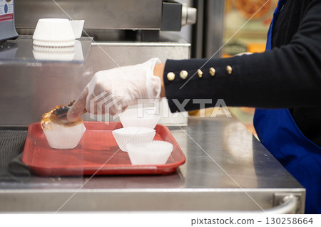 A woman's hands serving food at the tasting corner of a supermarket A woman's hands serving food at the tasting corner of a supermarket 130258664