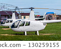 Two private small white helicopters at the airfield 130259155