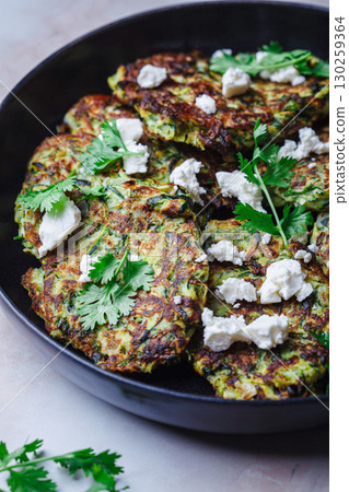 Green zucchini pancakes with feta and cilantro. Vegetarian breakfast recipe. Green zucchini pancakes with feta and cilantro. Vegetarian breakfast recipe. 130259364