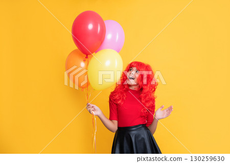 amazed teen girl with party balloon on yellow background 130259630