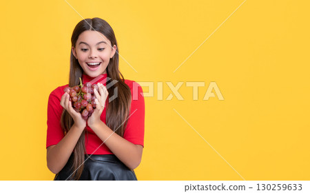 amazed kid hold bunch of grapes on yellow background amazed kid hold bunch of grapes on yellow background 130259633
