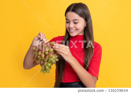 happy child hold fresh grapes fruit on yellow background happy child hold fresh grapes fruit on yellow background 130259634