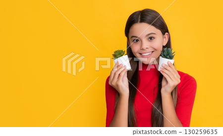 positive kid with cactus in pot on yellow background positive kid with cactus in pot on yellow background 130259635