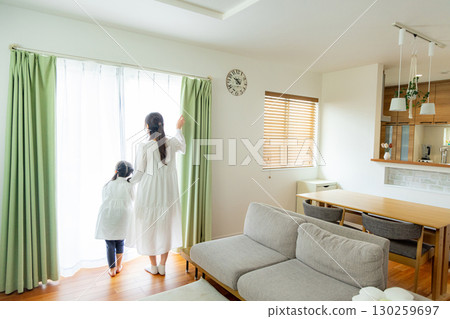 Parent and child relaxing in the living room 130259697