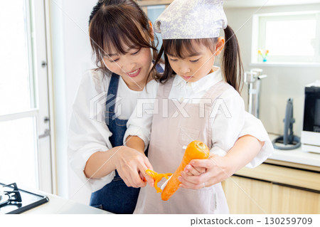 一名小學生和她的母親削胡蘿蔔 130259709
