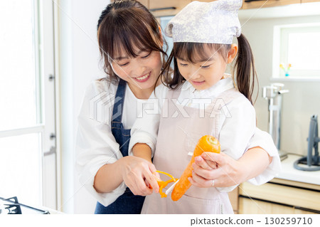 一名小學生和她的母親削胡蘿蔔 130259710
