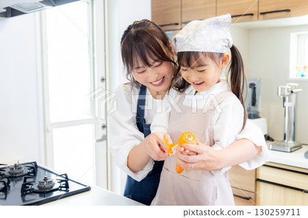 一名小學生和她的母親削胡蘿蔔 130259711