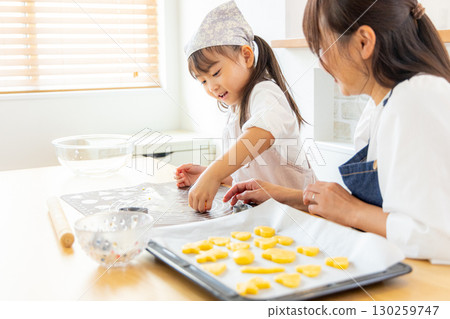 Parent and child making cookies 130259747