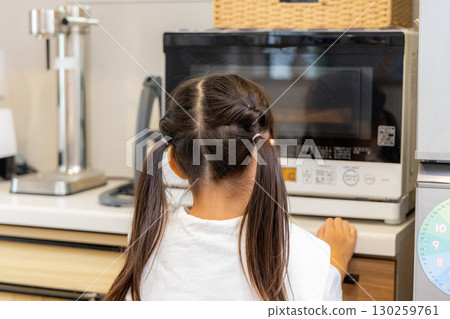 Elementary school student staring at microwave 130259761